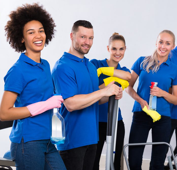 a cheerful professional cleaning team wearing their blue shirt uniform holding a cleaning products and equipment